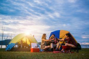 Publiplas|group man woman enjoy camping picnic barbecue lake with tents background young mixed race asian woman man young people s hands toasting cheering bottles beer 1253 1041